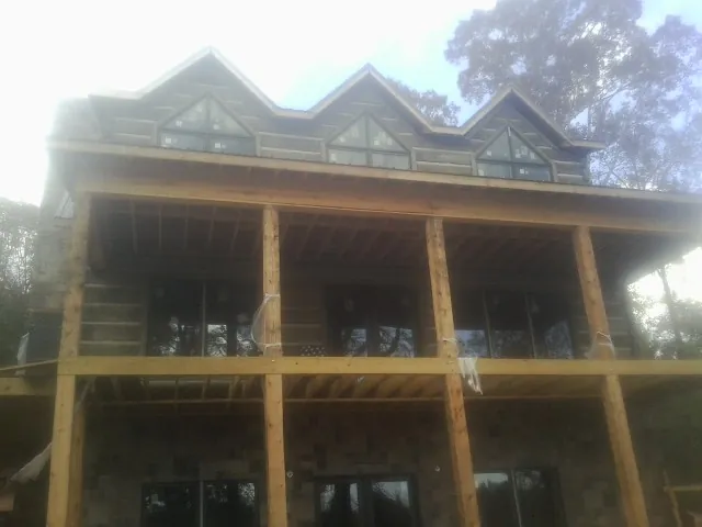 Dormers and porch framing on a large log home under construction — Roof Coating work by our crew in Sammamish