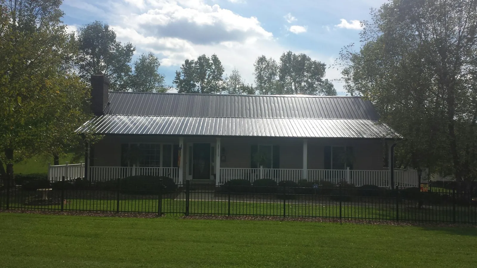 Gray metal roof on a brick ranch with a full width front porch in Sammamish